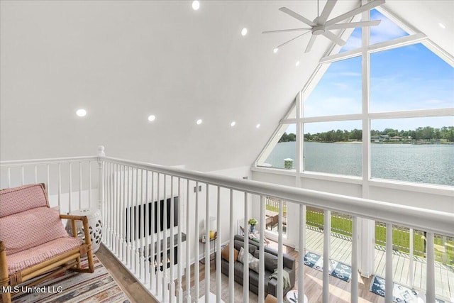 hallway featuring hardwood / wood-style flooring, vaulted ceiling, and a water view