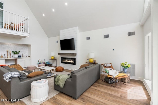 living room featuring a high ceiling and light wood-type flooring