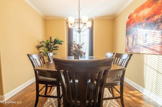 dining space featuring dark wood-type flooring, ornamental molding, and an inviting chandelier