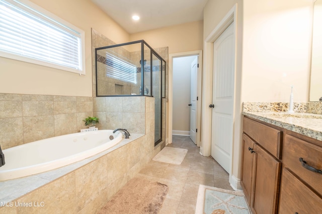 bathroom featuring tile patterned floors, a garden tub, a shower stall, and vanity