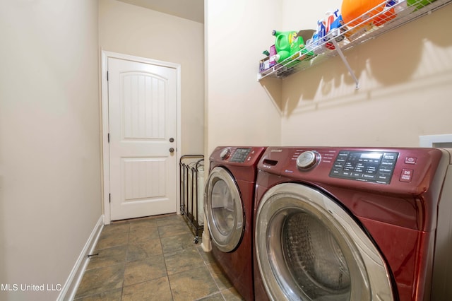 laundry room with stone finish flooring, washing machine and clothes dryer, laundry area, and baseboards