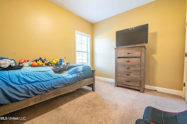bedroom with baseboards and light carpet