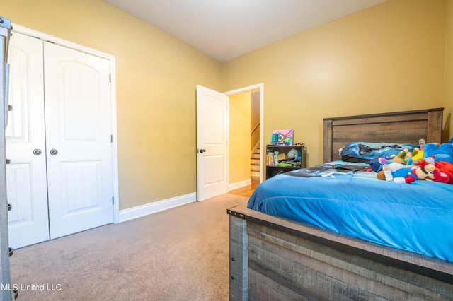 carpeted bedroom with a closet and baseboards