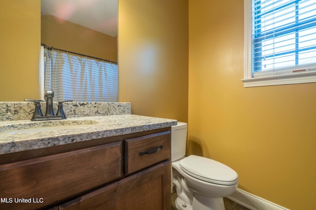 bathroom featuring a shower with shower curtain, baseboards, toilet, vanity, and tile patterned flooring
