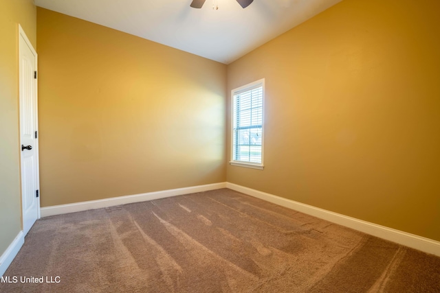 carpeted empty room with a ceiling fan and baseboards