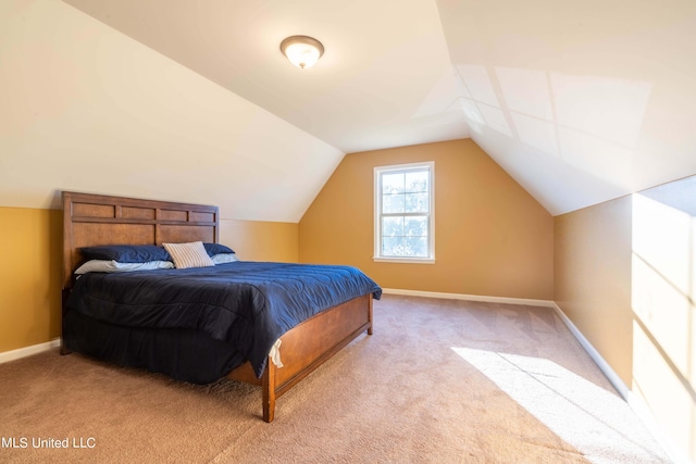 carpeted bedroom with baseboards and lofted ceiling