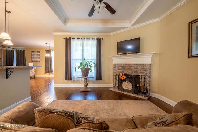 living room with crown molding, dark wood-type flooring, and a fireplace