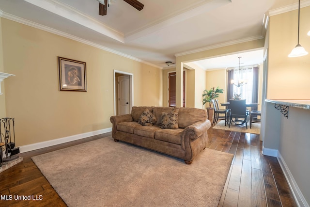 living room with a raised ceiling, ornamental molding, ceiling fan with notable chandelier, and dark hardwood / wood-style flooring