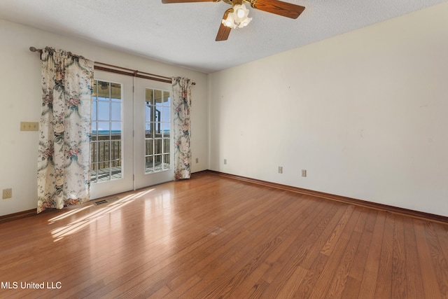 empty room with hardwood / wood-style floors, ceiling fan, and a textured ceiling