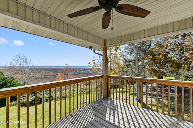 wooden terrace with ceiling fan and a yard