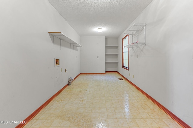 clothes washing area featuring built in shelves, hookup for a gas dryer, hookup for a washing machine, and a textured ceiling