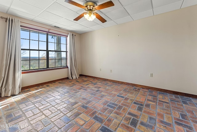 unfurnished room with a drop ceiling and ceiling fan