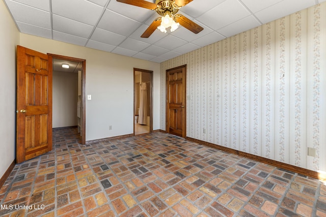 unfurnished bedroom featuring a drop ceiling and ceiling fan