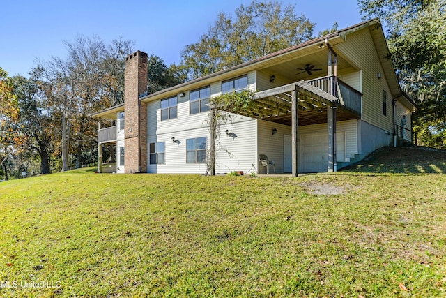 rear view of property with a yard, a garage, ceiling fan, and a wooden deck