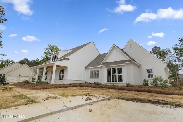 184 Harbor View Dr, Madison, MS 39110 - view of front facade with a porch, a garage, board and batten siding, and central AC
