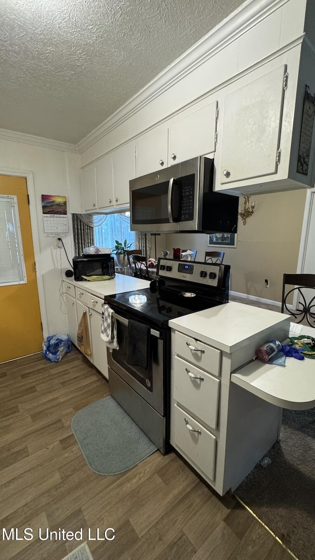 211 Boyd St, Ridgeland, MS 39157 - kitchen featuring appliances with stainless steel finishes, dark wood-style flooring, crown molding, white cabinetry, and light countertops
