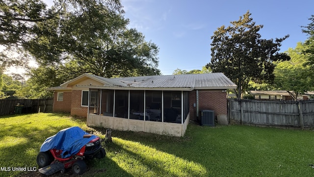 211 Boyd St, Ridgeland, MS 39157 - back of house featuring a sunroom, a fenced backyard, brick siding, and a metal roof