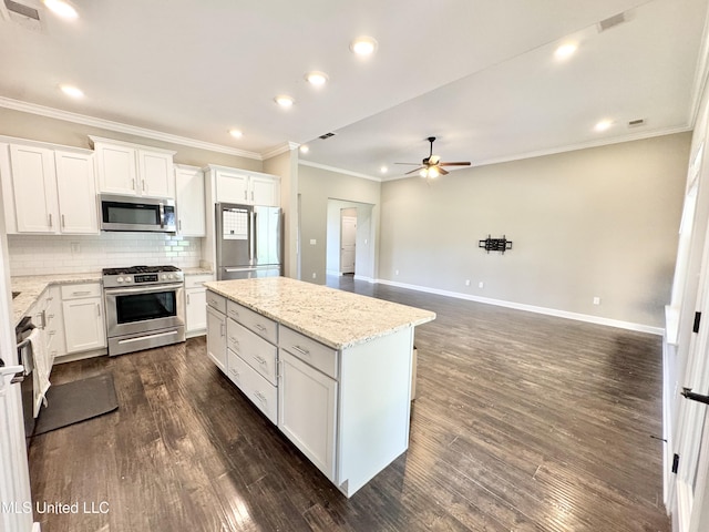 3464 Delaney Dr, Nesbit, MS 38651 - kitchen featuring stainless steel appliances, ceiling fan, a kitchen island, dark wood-type flooring, and backsplash