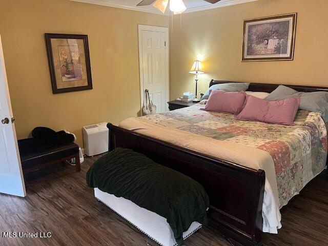 bedroom featuring ceiling fan, dark hardwood / wood-style floors, and crown molding