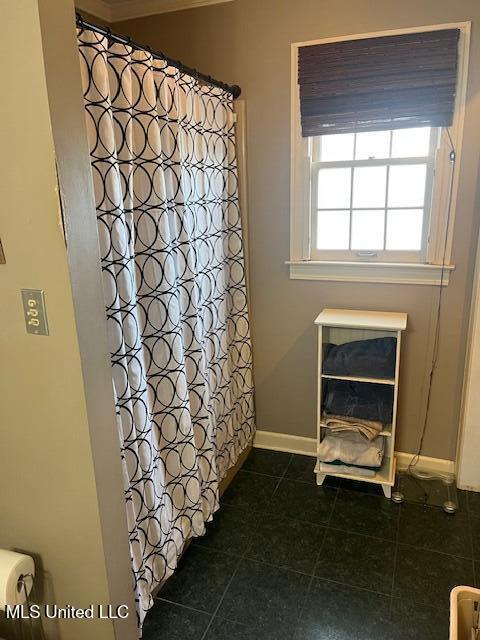 bathroom featuring curtained shower and tile patterned flooring