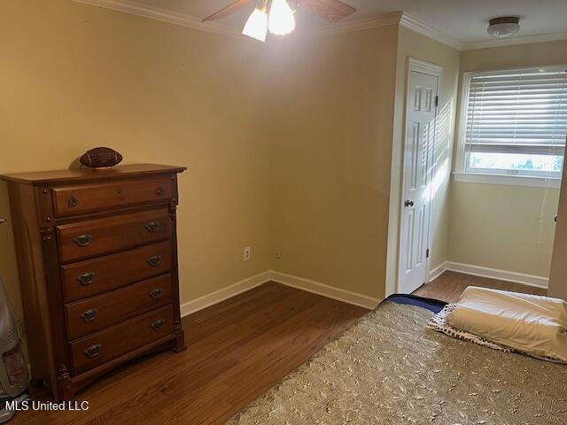 unfurnished bedroom with dark hardwood / wood-style floors, ceiling fan, and crown molding