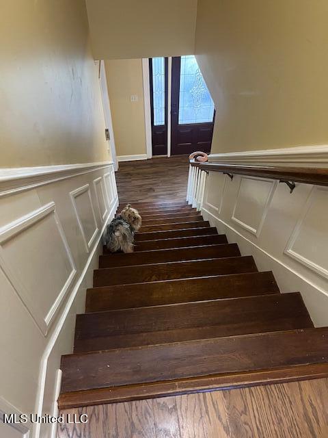 715 Sumner Ave, Greenwood, MS 38930 - stairway with wood finished floors, wainscoting, and a decorative wall