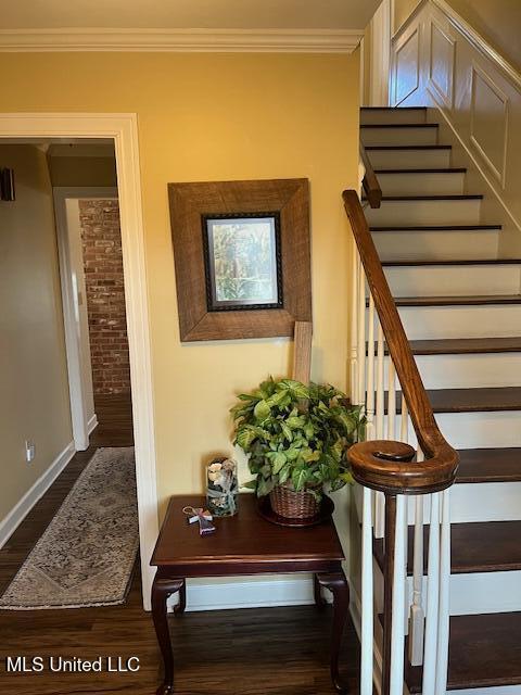 staircase with crown molding and hardwood / wood-style floors