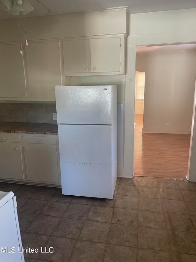 kitchen with decorative backsplash, dark wood-type flooring, white cabinets, and white fridge