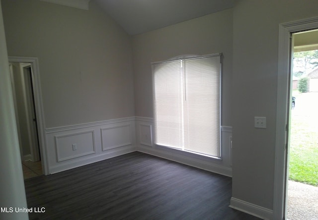 spare room with dark wood-type flooring and vaulted ceiling