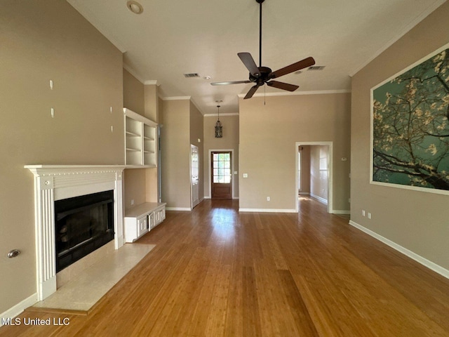 104 Warrior Ln, Clinton, MS 39056 - unfurnished living room with ceiling fan, crown molding, a fireplace, built in shelves, and wood finished floors