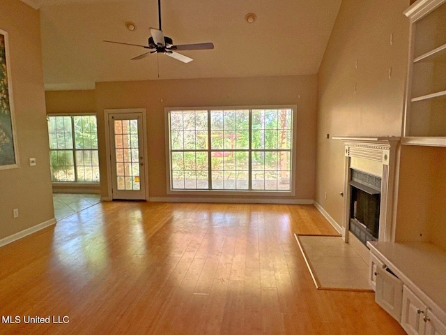 104 Warrior Ln, Clinton, MS 39056 - unfurnished living room featuring a fireplace with flush hearth, ceiling fan, baseboards, light wood-style flooring, and lofted ceiling