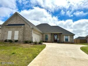 view of front facade with driveway, a garage, and a front yard