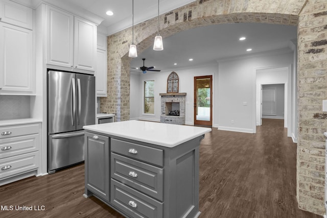 kitchen with a fireplace, gray cabinets, freestanding refrigerator, dark wood-type flooring, and white cabinetry