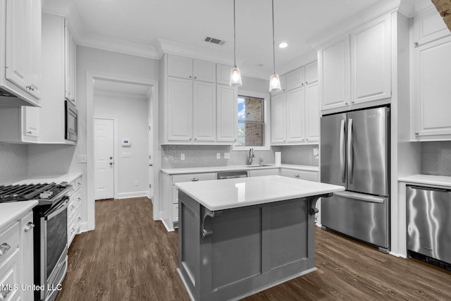 kitchen featuring crown molding, light countertops, stainless steel appliances, white cabinetry, and a sink