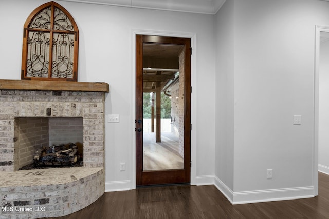 living room featuring baseboards, dark wood finished floors, and a fireplace