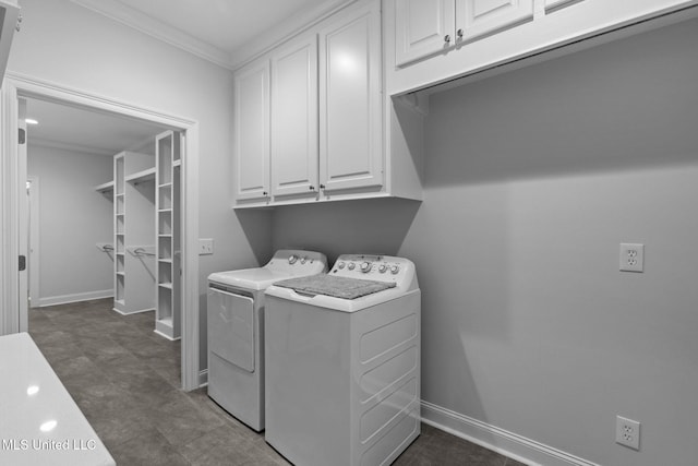 laundry room featuring ornamental molding, cabinet space, baseboards, and washing machine and clothes dryer