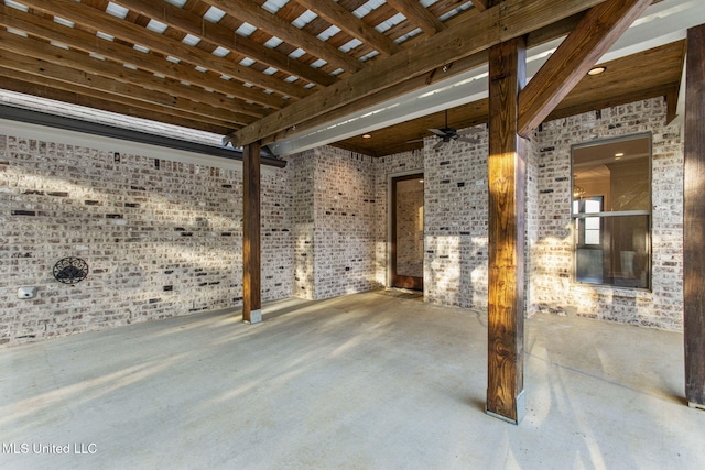 exterior space featuring brick wall and concrete floors