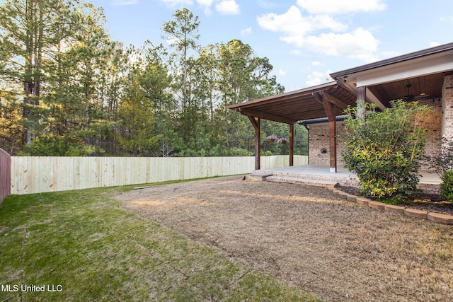 view of yard with a patio, a ceiling fan, and a fenced backyard