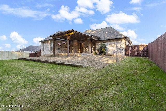 rear view of property with a patio, a yard, a fenced backyard, and brick siding