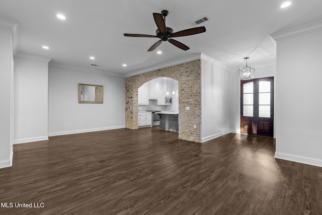 unfurnished living room featuring visible vents, arched walkways, dark wood-type flooring, and crown molding