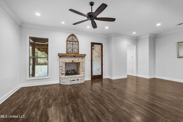 unfurnished living room featuring a brick fireplace, baseboards, ornamental molding, recessed lighting, and dark wood-style flooring