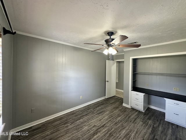 unfurnished bedroom with visible vents, built in study area, ornamental molding, dark wood-style flooring, and a textured ceiling