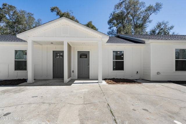 view of front facade featuring a shingled roof and board and batten siding