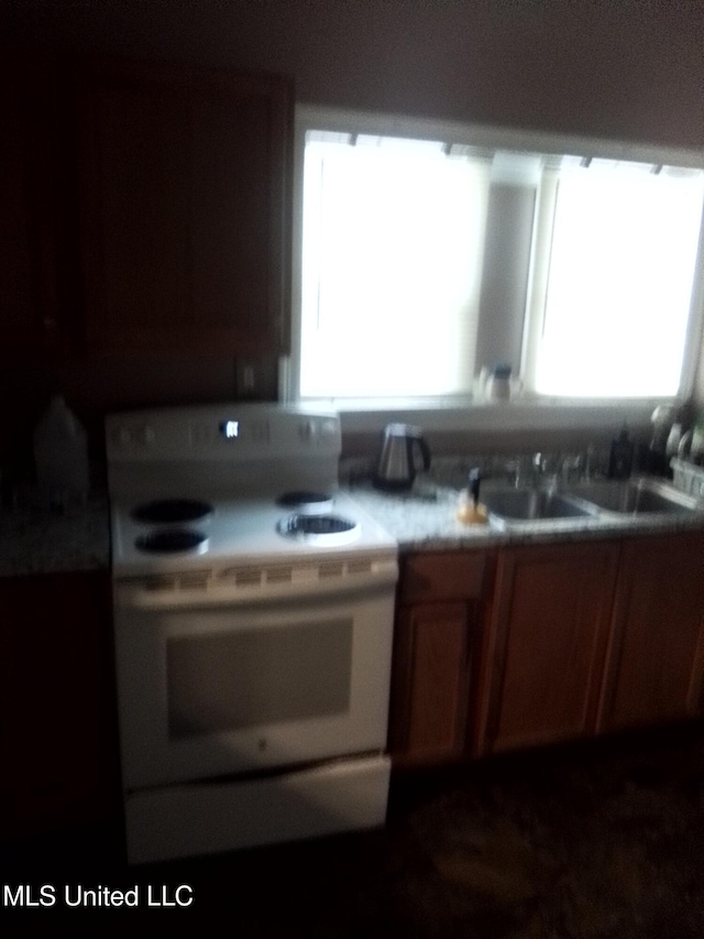 720 Mattingly St, Vicksburg, MS 39180 - kitchen featuring white range with electric cooktop, light countertops, and brown cabinetry