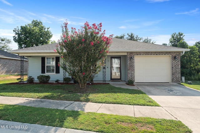 ranch-style house featuring concrete driveway, a shingled roof, a front yard, and a garage