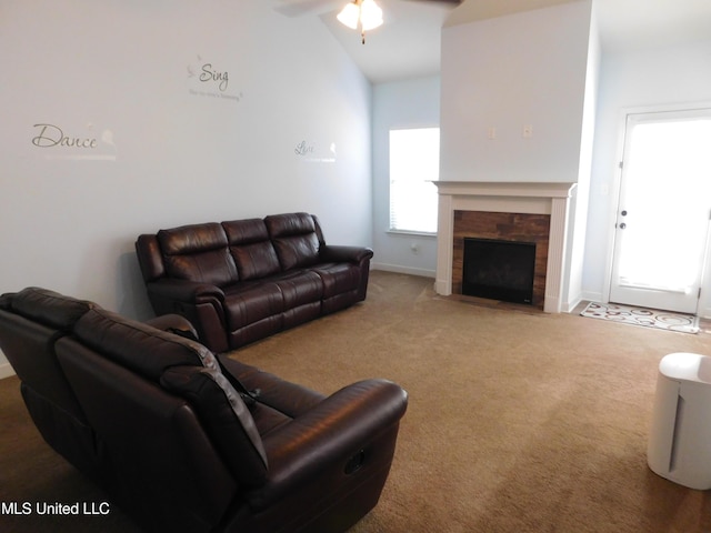 living room with vaulted ceiling, ceiling fan, carpet flooring, and a fireplace