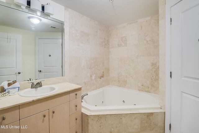 bathroom featuring vanity, a relaxing tiled tub, and tile walls