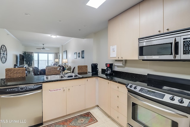 kitchen featuring ceiling fan, sink, stainless steel appliances, kitchen peninsula, and light tile patterned floors