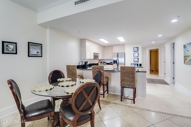 tiled dining room featuring ornamental molding