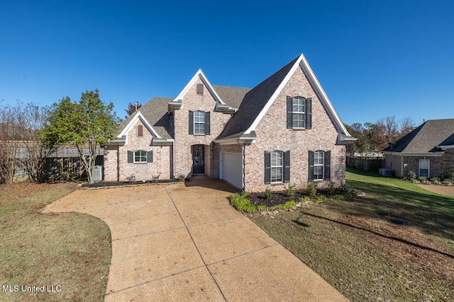 view of front of property with cooling unit, a garage, and a front yard